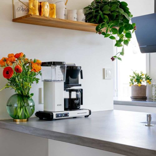 En hvit Moccamaster Automatic kaffetrakter som står plassert på en kjøkkenbenk